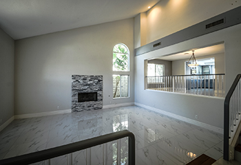 Modern entryway renovation with marble flooring and wooden staircase in Alhambra